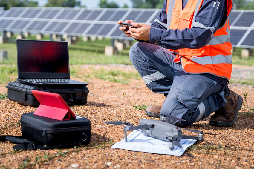 Engineers preparing drones to fly, inspecting the solar cells at high angles to thermo scan the solar panel for potential malfunctions and overheating. Alternative energy to conserve world's energy.